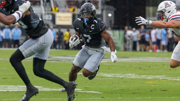 Nov 2, 2024; Orlando, Florida, USA; UCF Knights running back RJ Harvey (7) runs the ball against the Arizona Wildcats during the first quarter at FBC Mortgage Stadium. Nov 2, 2024; Orlando, Florida, USA; UCF Knights running back RJ Harvey (7) runs the ball against the Arizona Wildcats during the first quarter at FBC Mortgage Stadium.