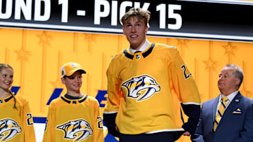 Jun 28, 2023; Nashville, Tennessee, USA; Nashville Predators draft pick Matthew Wood puts on his sweater after being selected with the fifteenth pick in round one of the 2023 NHL Draft at Bridgestone Arena. Mandatory Credit: Christopher Hanewinckel-Imagn Images