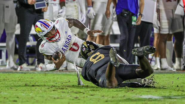 Kansas Jayhawks quarterback Jalon Daniels (6) is tackled by UCF Knights defensive end Isaiah Nixon (6).