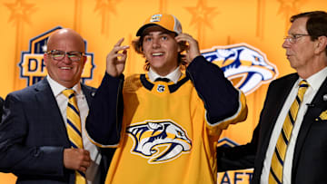 Jun 28, 2023; Nashville, Tennessee, USA; Nashville Predators draft pick Tanner Molendyk puts on a hat after being selected with the twenty fourth pick in round one of the 2023 NHL Draft at Bridgestone Arena. Mandatory Credit: Christopher Hanewinckel-Imagn Images