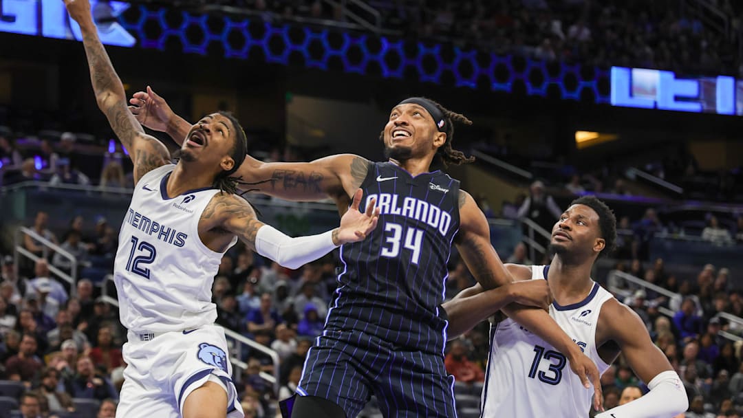 Feb 21, 2025; Orlando, Florida, USA; Memphis Grizzlies guard Ja Morant (12), forward Jaren Jackson Jr. (13) and Orlando Magic center Wendell Carter Jr. (34) look for the rebound during the second quarter at Kia Center. Mandatory Credit: Mike Watters-Imagn Images
