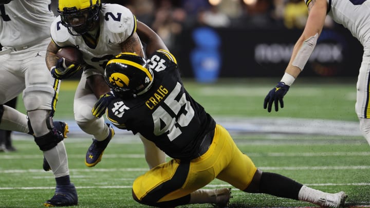 Dec 2, 2023; Indianapolis, IN, USA; Michigan Wolverines running back Blake Corum (2) is tackled by Iowa Hawkeyes defensive lineman Deontae Craig (45) during the second half of the Big Ten Championship game at Lucas Oil Stadium. Mandatory Credit: Trevor Ruszkowski-USA TODAY Sports