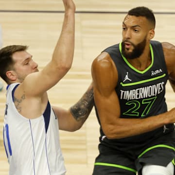 May 30, 2024; Minneapolis, Minnesota, USA; Minnesota Timberwolves center Rudy Gobert (27) looks to pass against Dallas Mavericks guard Luka Doncic (77) during the first quarter in game five of the western conference finals for the 2024 NBA playoffs at Target Center. Mandatory Credit: Bruce Kluckhohn-Imagn Images