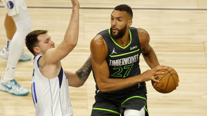 May 30, 2024; Minneapolis, Minnesota, USA; Minnesota Timberwolves center Rudy Gobert (27) looks to pass against Dallas Mavericks guard Luka Doncic (77) during the first quarter in game five of the western conference finals for the 2024 NBA playoffs at Target Center. Mandatory Credit: Bruce Kluckhohn-Imagn Images