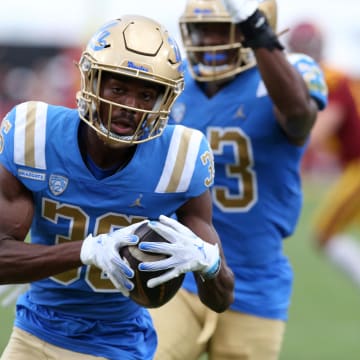 Nov 18, 2023; Los Angeles, California, USA; UCLA Bruins defensive back Alex Johnson (36) returns a fumble for a touchdown during the third quarter against the USC Trojans at United Airlines Field at Los Angeles Memorial Coliseum. 