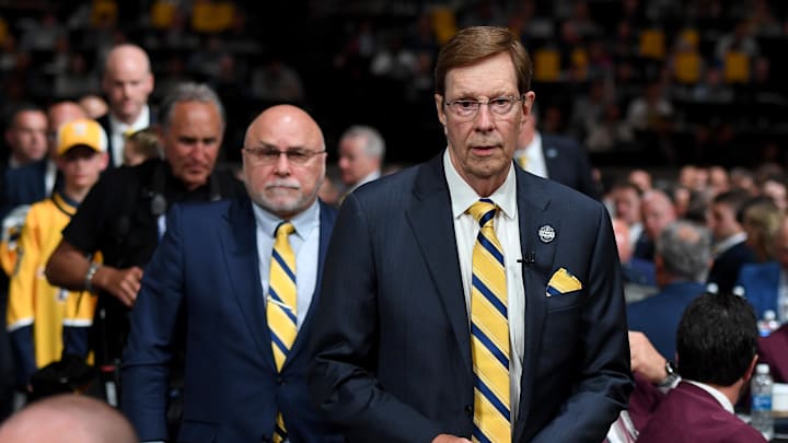 Jun 28, 2023; Nashville, Tennessee, USA; Nashville Predators outgoing general manager David Poile walks to the stage in front of incoming general manager Barry Trotz before the Predators make the fifteenth pick in round one of the 2023 NHL Draft at Bridgestone Arena. Mandatory Credit: Christopher Hanewinckel-Imagn Images
