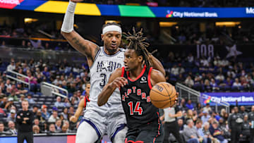 Mar 4, 2025; Orlando, Florida, USA; Toronto Raptors guard Ja'Kobe Walter (14) drives around Orlando Magic center Wendell Carter Jr. (34) during the second half at Kia Center. Mandatory Credit: Mike Watters-Imagn Images