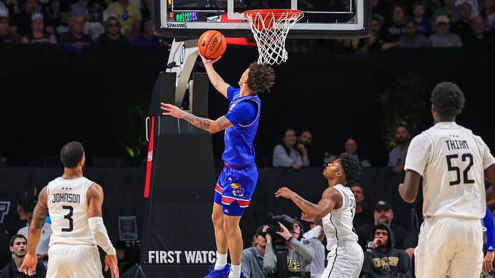 Jan 5, 2025; Orlando, Florida, USA; Kansas Jayhawks guard Zeke Mayo (5) goes to the basket against UCF Knights guard Jordan Ivy-Curry (0) during the first half at Addition Financial Arena. Mandatory Credit: Mike Watters-Imagn Images