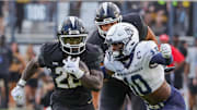 Aug 29, 2024; Orlando, Florida, USA; UCF Knights running back Myles Montgomery (22) runs the ball as New Hampshire Wildcats safety Zedane Williams (10) moves in for the tackle during the first quarter at FBC Mortgage Stadium. Mandatory Credit: Mike Watters-Imagn Images
