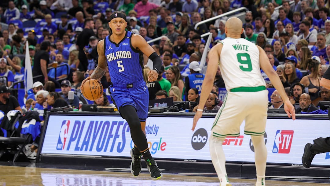 Apr 25, 2025; Orlando, Florida, USA; Orlando Magic forward Paolo Banchero (5) brings the ball up court against Boston Celtics guard Derrick White (9) during the first quarter of game three of first round for the 2024 NBA Playoffs at Kia Center. Mandatory Credit: Mike Watters-Imagn Images