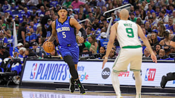 Apr 25, 2025; Orlando, Florida, USA; Orlando Magic forward Paolo Banchero (5) brings the ball up court against Boston Celtics guard Derrick White (9) during the first quarter of game three of first round for the 2024 NBA Playoffs at Kia Center. Mandatory Credit: Mike Watters-Imagn Images