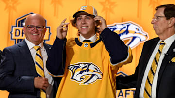 Jun 28, 2023; Nashville, Tennessee, USA; Nashville Predators draft pick Tanner Molendyk puts on a hat after being selected with the twenty fourth pick in round one of the 2023 NHL Draft at Bridgestone Arena. Mandatory Credit: Christopher Hanewinckel-Imagn Images
