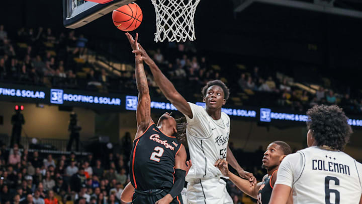 Mar 5, 2025; Orlando, Florida, USA; UCF Knights center Moustapha Thiam (52) blocks a shot by Oklahoma State Cowboys guard Arturo Dean (2) during the first half at Addition Financial Arena. Mandatory Credit: Mike Watters-Imagn Images Mar 5, 2025; Orlando, Florida, USA; UCF Knights center Moustapha Thiam (52) blocks a shot by Oklahoma State Cowboys guard Arturo Dean (2) during the first half at Addition Financial Arena. Mandatory Credit: Mike Watters-Imagn Images
