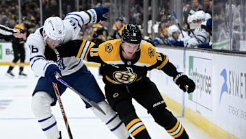 Feb 25, 2025; Boston, Massachusetts, USA; Boston Bruins center Trent Frederic (11) skates with the puck against Toronto Maple Leafs center Steven Lorentz (18) during the first period at the TD Garden. Mandatory Credit: Brian Fluharty-Imagn Images