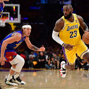 Apr 25, 2024; Los Angeles, California, USA; Los Angeles Lakers forward LeBron James (23) moves the ball against Denver Nuggets center Nikola Jokic (15) and forward Aaron Gordon (50) during the second half in game three of the first round for the 2024 NBA playoffs at Crypto.com Arena. Mandatory Credit: Gary A. Vasquez-Imagn Images