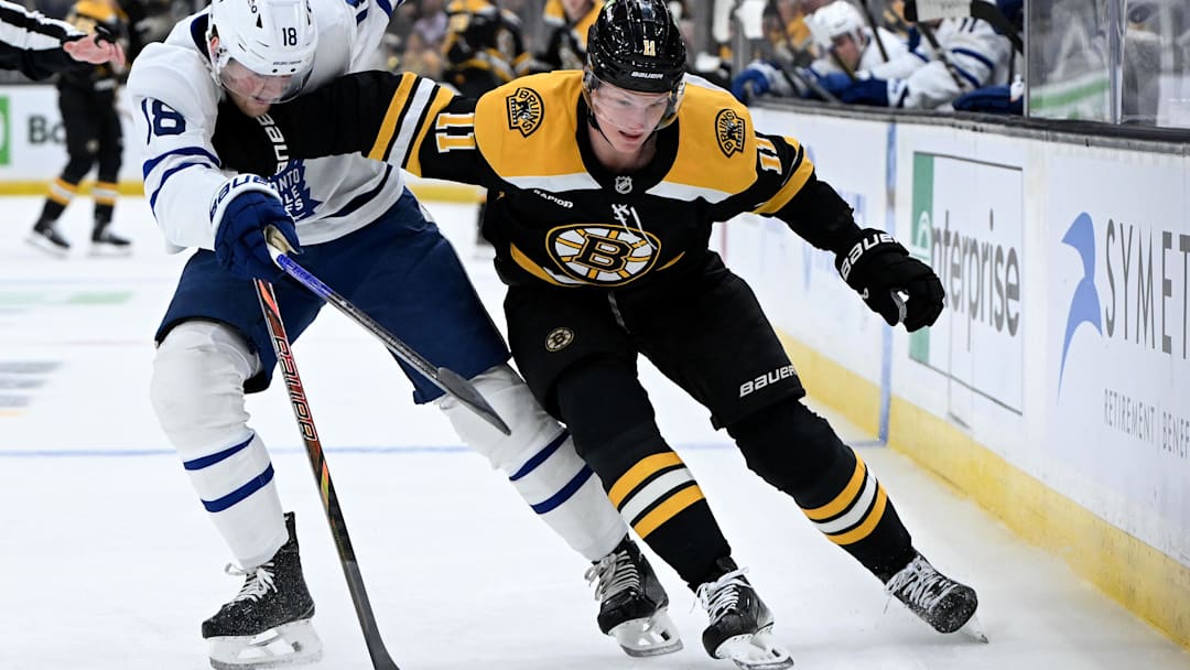 Feb 25, 2025; Boston, Massachusetts, USA; Boston Bruins center Trent Frederic (11) skates with the puck against Toronto Maple Leafs center Steven Lorentz (18) during the first period at the TD Garden. Mandatory Credit: Brian Fluharty-Imagn Images