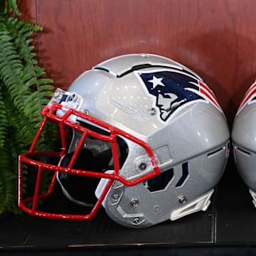 Jan 13, 2025; Foxborough, MA, USA; A pair of New England Patriots helmets sit in front of the podium before a press conference at Gillette Stadium. Mandatory Credit: Eric Canha-Imagn Images