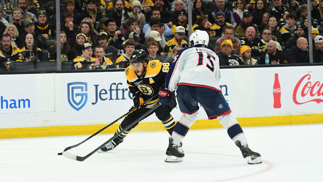 Blue Jackets defenseman Dante Fabbro defends Bruins forward David Pastrnak. Blue Jackets defenseman Dante Fabbro defends Bruins forward David Pastrnak.