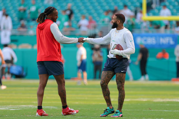 Miami Dolphins wide receiver Odell Beckham Jr. and New England Patriots quarterback Joe Milton III shake hands before a game.
