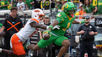 Oregon’s Dakorien Moore, right, flies over the goal line ahead of Oklahoma State’s David Kabongo for a second quarter touchdown at Autzen.