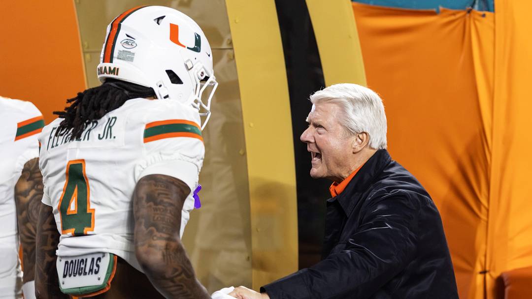 Jan 19, 2026; Miami Gardens, FL, USA; Miami Hurricanes former player Jimmy Johnson (right) greets running back Mark Fletcher Jr (4) on the field prior to the game against the Indiana Hoosiers during the College Football Playoff National Championship game at Hard Rock Stadium. Mandatory Credit: Mark J. Rebilas-Imagn Images