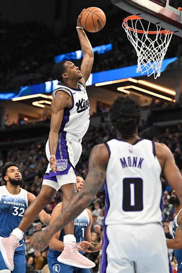Sacramento Kings guard De'Aaron Fox (5) completes a dunk as guard Malik Monk (0)