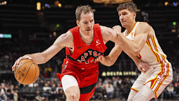 Jan 25, 2025; Atlanta, Georgia, USA; Toronto Raptors center Jakob Poeltl (19) dribbles guarded by Atlanta Hawks guard Bogdan Bogdanovic (13) during the second half at State Farm Arena. Mandatory Credit: Dale Zanine-Imagn Images