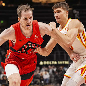 Jan 25, 2025; Atlanta, Georgia, USA; Toronto Raptors center Jakob Poeltl (19) dribbles guarded by Atlanta Hawks guard Bogdan Bogdanovic (13) during the second half at State Farm Arena. Mandatory Credit: Dale Zanine-Imagn Images