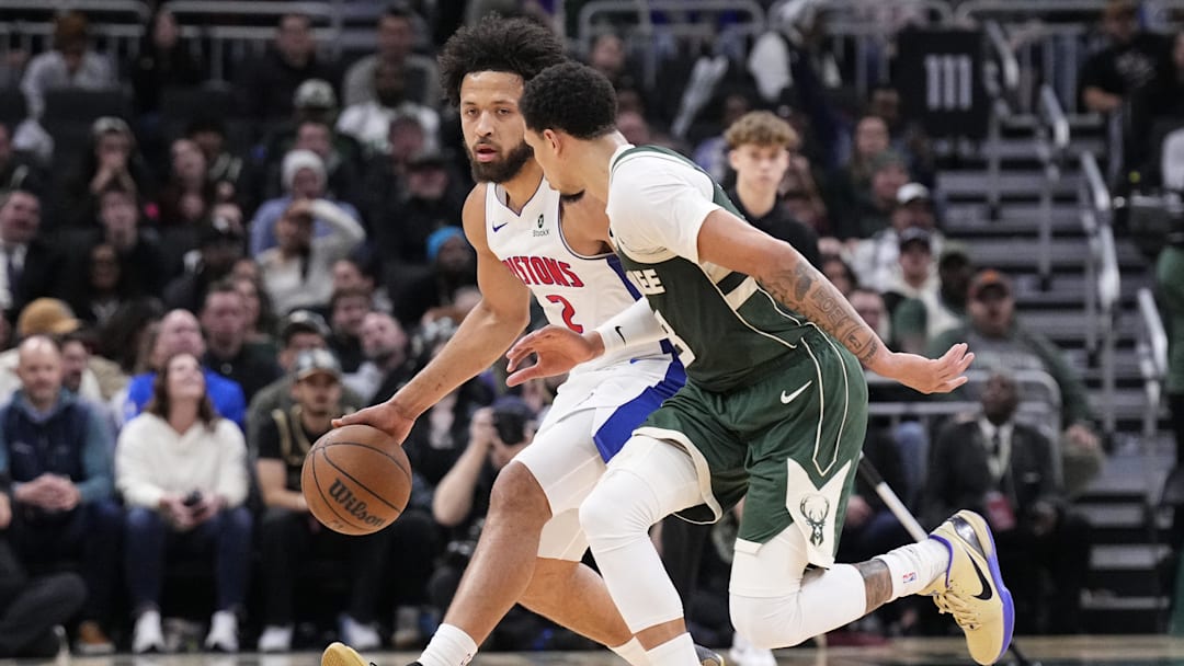 Dec 3, 2025; Milwaukee, Wisconsin, USA;  Detroit Pistons guard Cade Cunningham (2) brings the ball up the court against Milwaukee Bucks guard Ryan Rollins (13) in the second half at Fiserv Forum. Mandatory Credit: Michael McLoone-Imagn Images