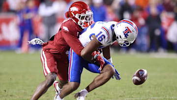 Nov 23, 2024; Fayetteville, Arkansas, USA; Arkansas Razorbacks defensive back Doneiko Slaughter (3) forces a fumble against Louisiana Tech Bulldogs wide receiver Tru Edwards (16) during the fourth quarter at Donald W. Reynolds Razorback Stadium. Arkansas won 35-14. Mandatory Credit: Nelson Chenault-Imagn Images