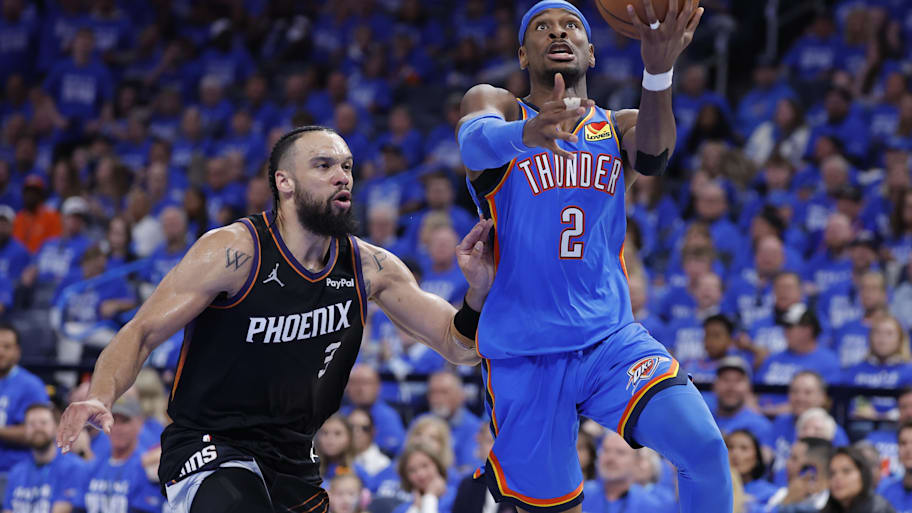 Oklahoma City Thunder guard Shai Gilgeous-Alexander goes up for a basket beside Phoenix Suns forward Dillon Brooks.