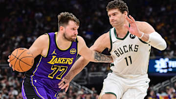 Los Angeles Lakers guard Luka Doncic (77) drives to the basket against Milwaukee Bucks center Brook Lopez (11) in the fourth quarter at Fiserv Forum.