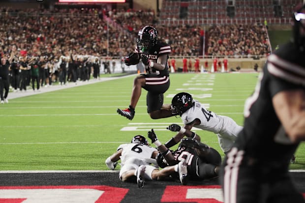 Texas Tech Red Raiders running back Tahj Brooks hurdles Cincinnati Bearcats safety Trevon Gola-Callard for a touchdown.