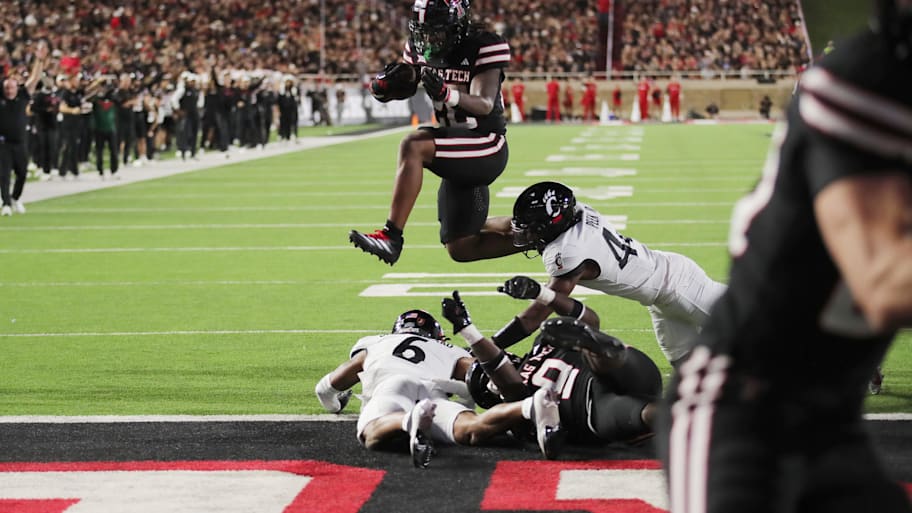 Texas Tech Red Raiders running back Tahj Brooks hurdles Cincinnati Bearcats safety Trevon Gola-Callard for a touchdown.