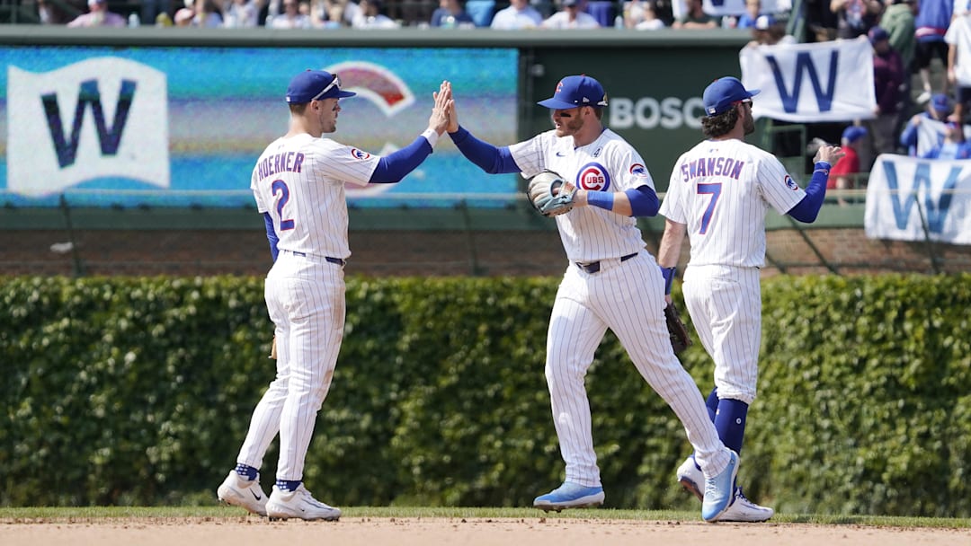 Jun 1, 2025; Chicago, Illinois, USA; Chicago Cubs second baseman Nico Hoerner (2), outfielder Ian Happ (center), and shortstop Dansby Swanson (7) celebrate their win against the Cincinnati Reds at Wrigley Field. Mandatory Credit: David Banks-Imagn Images