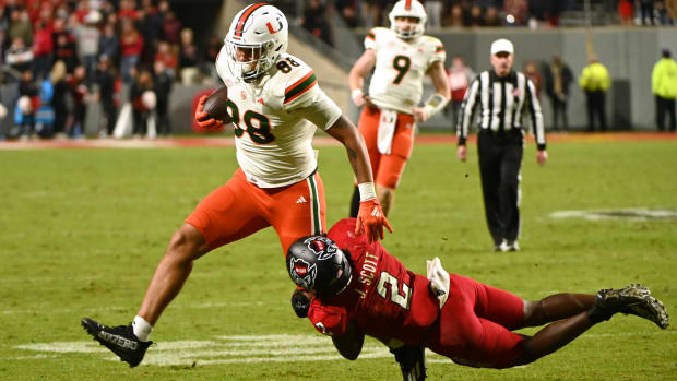 Miami Hurricanes tight end Riley Williams (88) is tackled by North Carolina State Wolfpack linebacker Jaylon Scott (2)