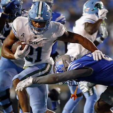 Oct 13, 2023; Memphis, Tennessee, USA; Tulane Green Wave running back Makhi Hughes (21) runs the ball as Memphis Tigers defensive linemen Zy Brockington (0) attempts to make the tackle during the second half at Simmons Bank Liberty Stadium. Mandatory Credit: Petre Thomas-Imagn Images