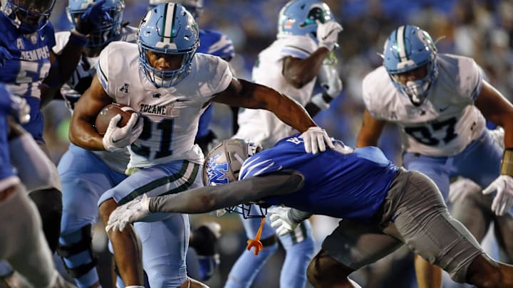 Oct 13, 2023; Memphis, Tennessee, USA; Tulane Green Wave running back Makhi Hughes (21) runs the ball as Memphis Tigers defensive linemen Zy Brockington (0) attempts to make the tackle during the second half at Simmons Bank Liberty Stadium. 