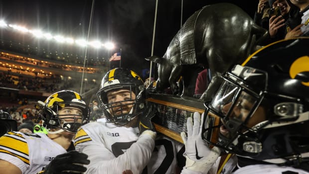 Iowa Hawkeyes players celebrate with the Floyd of Rosedale after defeating the Minnesota Golden Gophers.