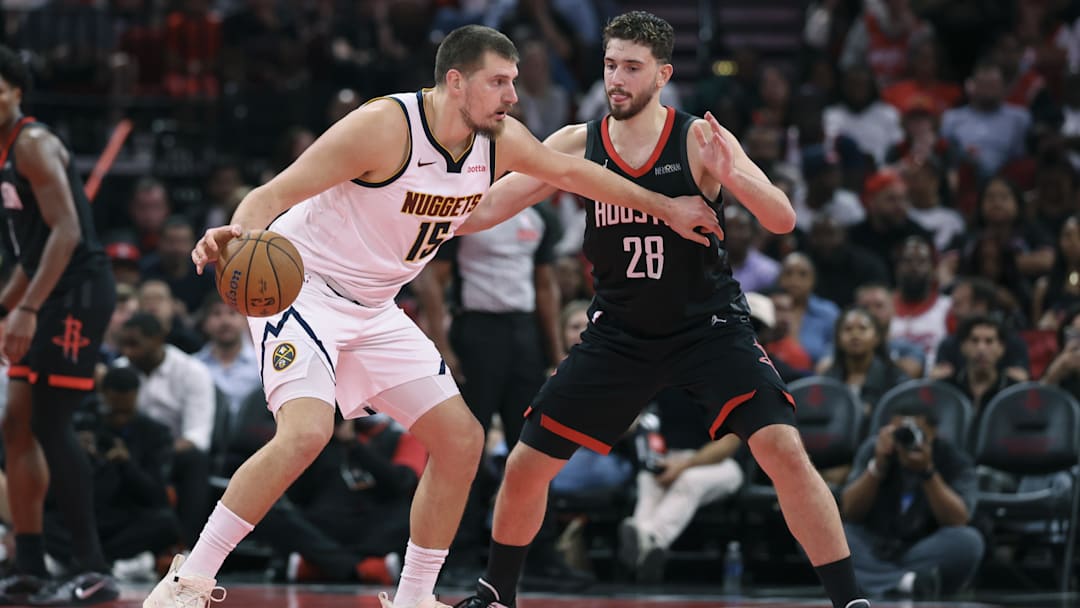 Nov 21, 2025; Houston, Texas, USA; Denver Nuggets center Nikola Jokic (15) controls the ball as Houston Rockets center Alperen Sengun (28) defends during the second quarter at Toyota Center. Mandatory Credit: Troy Taormina-Imagn Images