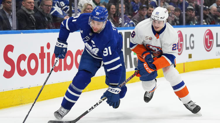 Jan 23, 2023; Toronto, Ontario, CAN; Toronto Maple Leafs center John Tavares (91) battles for the puck with New York Islanders defenseman Alexander Romanov (28) during the first period at Scotiabank Arena. Mandatory Credit: Nick Turchiaro-USA TODAY Sports