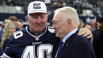Dallas Cowboys owner Jerry Jones talks with Bill Bates, former player, before the game against the Washington Commanders