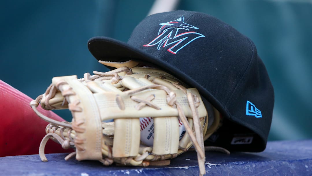 Apr 24, 2024; Atlanta, Georgia, USA; A detailed view of a Miami Marlins hat and glove in the dugout before a game against the Atlanta Braves at Truist Park. Mandatory Credit: Brett Davis-Imagn Images