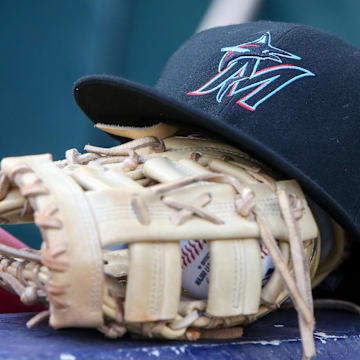 Apr 24, 2024; Atlanta, Georgia, USA; A detailed view of a Miami Marlins hat and glove in the dugout before a game against the Atlanta Braves at Truist Park. Mandatory Credit: Brett Davis-Imagn Images
