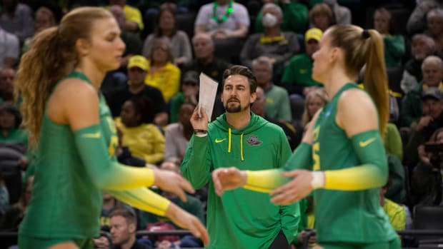 Oregon Volleyball coach Matt Ulmer, center, calls to his team during their NCAA Round 2 game against Arkansas