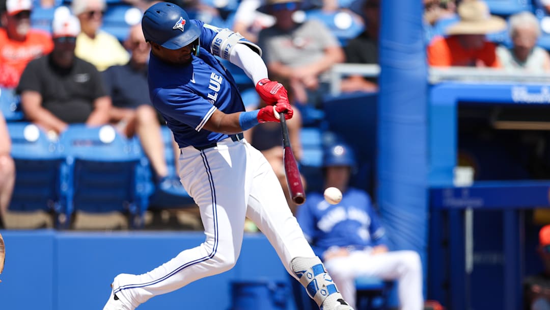 Mar 13, 2025: Toronto Blue Jays second baseman Orelvis Martinez (13) hits a base hit against the Baltimore Orioles in the second inning during spring training at TD Ballpark. 