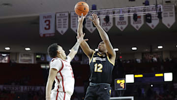 Missouri Tigers guard Tony Perkins (12) attempts a shot over a defender, in a game against the Oklahoma Sooners this season.