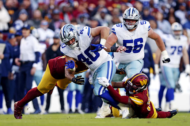 Dallas Cowboys running back Hunter Luepke runs the ball against Washington Commanders safety Percy Butler.