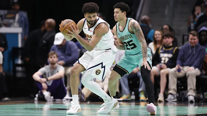 Feb 1, 2025; Charlotte, North Carolina, USA; Denver Nuggets guard Jamal Murray (27) is guarded by Charlotte Hornets guard KJ Simpson (25) during the second half of play at Spectrum Center. Mandatory Credit: Brian Westerholt-Imagn Images