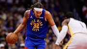 Nov 7, 2025; Denver, Colorado, USA; Denver Nuggets forward Aaron Gordon (32) controls the ball as Golden State Warriors forward Jonathan Kuminga (1) guards in the third quarter at Ball Arena. Mandatory Credit: Isaiah J. Downing-Imagn Images